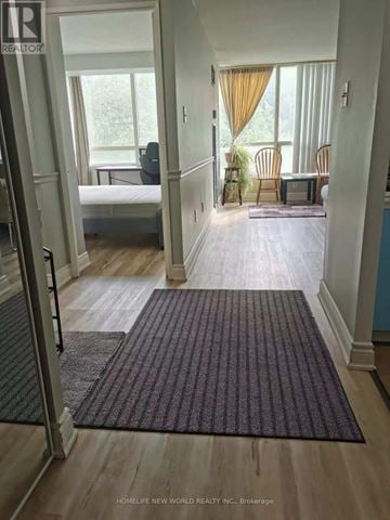 Toronto (Morningside) condo for rent - A room with a bed, a chair, and a table with a window in the background.