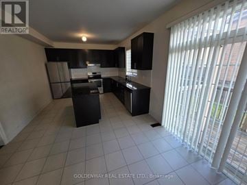 Newmarket (Stonehaven-Wyndham) apartment for rent - A kitchen with black cabinets and appliances in a sunny room.