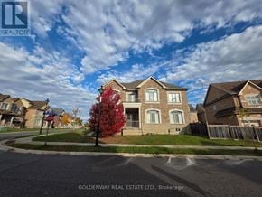 Newmarket (Stonehaven-Wyndham) apartment for rent - A tree with red leaves stands in front of a house with a sign that says REALTOR.