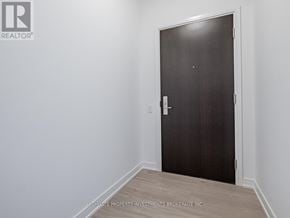 Mississauga (Hurontario) condo for rent - A dark brown door with a white handle in a room with white walls.