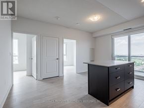 Mississauga (Hurontario) condo for rent - A spacious room with a large window, a black cabinet, and a white door.