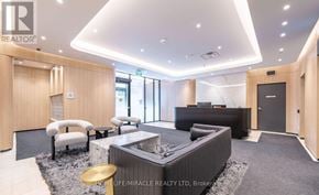 Toronto (Oakwood Village) condo for rent - A modern living room with a black sofa and a grey rug.