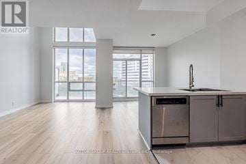 Mississauga (City Centre) condo for rent - A modern kitchen with a stainless steel dishwasher and wooden flooring.