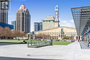 Mississauga (City Centre) condo for rent - A city park with a large building in the background and a tall tower.