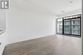 Toronto (Leaside) condo for rent - A spacious room with a view of a building through the windows.