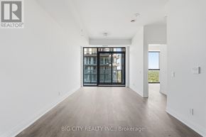 Toronto (Leaside) condo for rent - A spacious room with a view of the city through the glass doors.