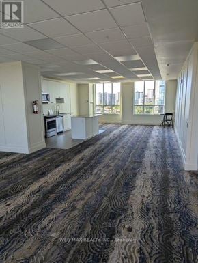 Toronto (Scarborough Village) condo for rent - A large, empty room with a carpeted floor and white walls.