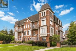 Brampton (Westgate) townhouse for rent - A large red brick building with a black fence in front.