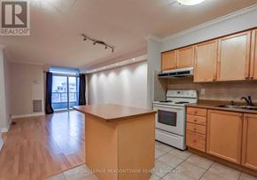 Mississauga (City Centre) condo for rent - A kitchen with wooden cabinets and a white stove top oven.