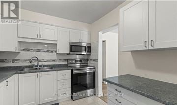 St. Catharines (Vine/Linwell) townhouse for rent - A kitchen with white cabinets and a granite countertop.
