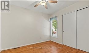 St. Catharines (Vine/Linwell) townhouse for rent - A room with a ceiling fan and a window with a view of trees.