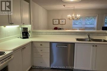 Collingwood townhouse for rent - A kitchen with white cabinets and a stainless steel dishwasher.
