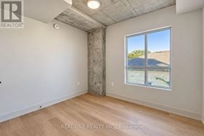 Hamilton (Westdale) condo for rent - A room with a large window showing a view of a hill and a building.
