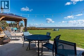 Upper Cape apartment for rent - A patio with a table and chairs overlooking the ocean.
