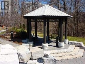 Toronto (Banbury-Don Mills) condo for rent - A gazebo with a metal roof is surrounded by stone pillars and a stone wall.