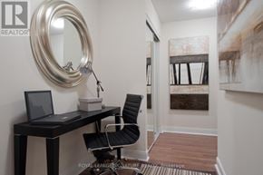 Toronto (Willowdale East) condo for rent - A black desk with a laptop and a chair in front of a mirror.