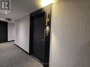 Toronto (Trinity-Bellwoods) condo for rent - A hallway with a door on the right and a sign on the wall.