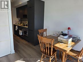 Toronto (Trinity-Bellwoods) condo for rent - A kitchen with a wooden table and chairs.