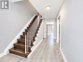 Toronto (L'amoreaux) townhouse for rent - A hallway with a staircase and a doorway at the end.
