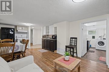 London East (East C) apartment for rent - A living room with a white couch, wooden chairs, and a coffee table with a plant on it.