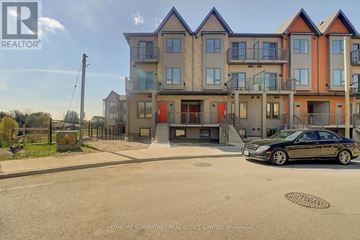 Pickering (Duffin Heights) townhouse for rent - A car is parked in front of a multi-story residential building.