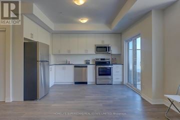 Pickering (Duffin Heights) townhouse for rent - A spacious kitchen with white cabinets and stainless steel appliances.