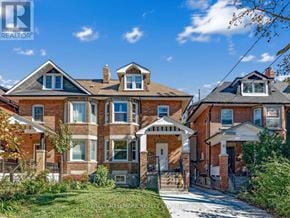 Toronto (Corso Italia-Davenport) triplex for rent - A large brick house with a white entrance and a small porch.