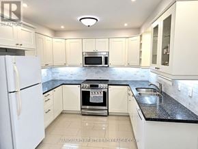 Vaughan (East Woodbridge) townhouse for rent - A kitchen with white cabinets and a black countertop.
