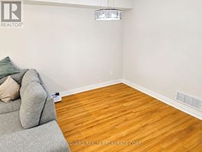 Vaughan (East Woodbridge) townhouse for rent - A room with a grey couch and wooden flooring.