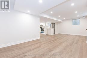 Milton (Fo Ford) apartment for rent - A spacious room with wooden flooring and white walls, with a logo of RE/MAX Realty Specialists Inc. Brokerage on the bottom left.