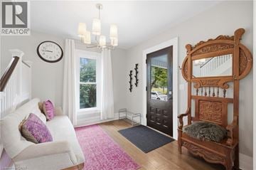 Niagara Falls apartment for rent - A living room with a white couch and a wooden chair.