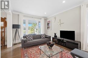 Niagara Falls (Downtown) apartment for rent - A living room with a grey couch, a glass coffee table, and a black television.