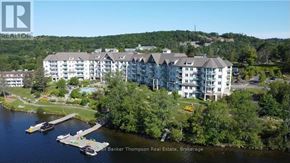 Huntsville (Chaffey) condo for rent - A brokerage office for real estate is located in a large building near a body of water.