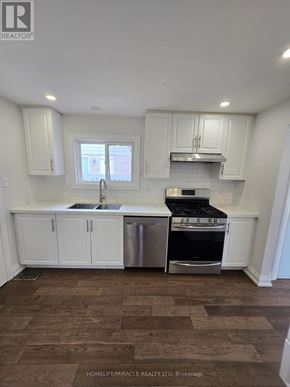 Toronto (L'amoreaux) apartment for rent - A kitchen with white cabinets and a wooden floor.