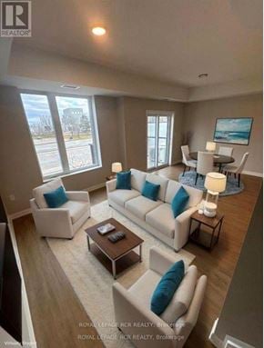 Guelph (Riverside Park) townhouse for rent - A living room with a white couch and blue pillows.