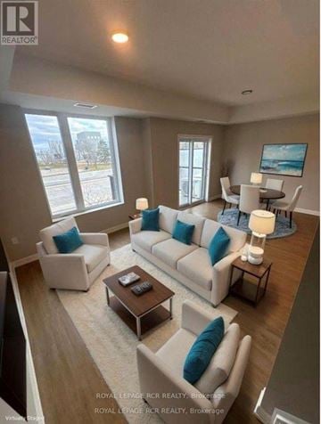 Guelph (Riverside Park) townhouse for rent - A living room with a white couch and blue pillows.