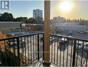 Guelph (Riverside Park) townhouse for rent - A balcony with a view of a parking lot and buildings.