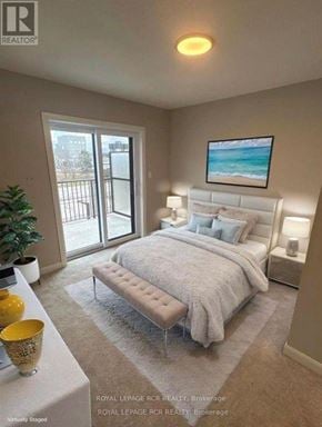 Guelph (Riverside Park) townhouse for rent - A bedroom with a large bed and a view of the outside.