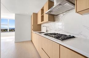 Surrey apartment for rent - A modern kitchen with a marble countertop and wooden cabinets.