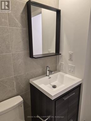 Vaughan (Vaughan Corporate Centre) condo for rent - A bathroom with a sink, toilet and mirror.