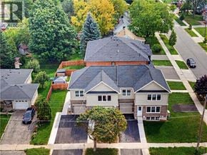 Kitchener apartment for rent - A large house with a grey roof is surrounded by a green lawn.