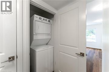 Kitchener apartment for rent - A white oven and dishwasher are built into a cabinet in a kitchen.
