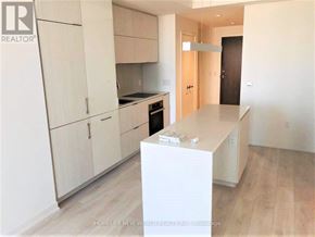 Toronto (Waterfront Communities) condo for rent - A kitchen with white cabinets and a wooden island.