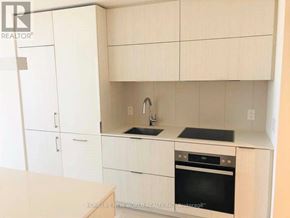 Toronto (Waterfront Communities) condo for rent - A kitchen with white cabinets and a black oven.