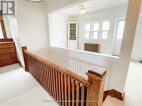 Toronto (Danforth Village-East York) apartment for rent - A room with a wooden staircase and a window with a view of a green tree.