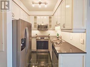 Toronto (Willowdale East) condo for rent - A modern kitchen with white cabinets and stainless steel appliances.