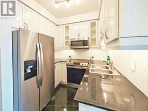 Toronto (Willowdale East) condo for rent - A modern kitchen with a stainless steel refrigerator and a microwave above the stove.