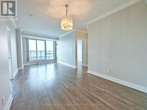 Toronto (Willowdale East) condo for rent - A large, empty room with wood flooring and a chandelier.