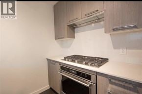 Richmond townhouse for rent - A modern kitchen with a stove top oven and a microwave above it.