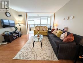 Mississauga (City Centre) condo for rent - A living room with a black couch and a coffee table.